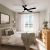 a bedroom with a bed and a fan